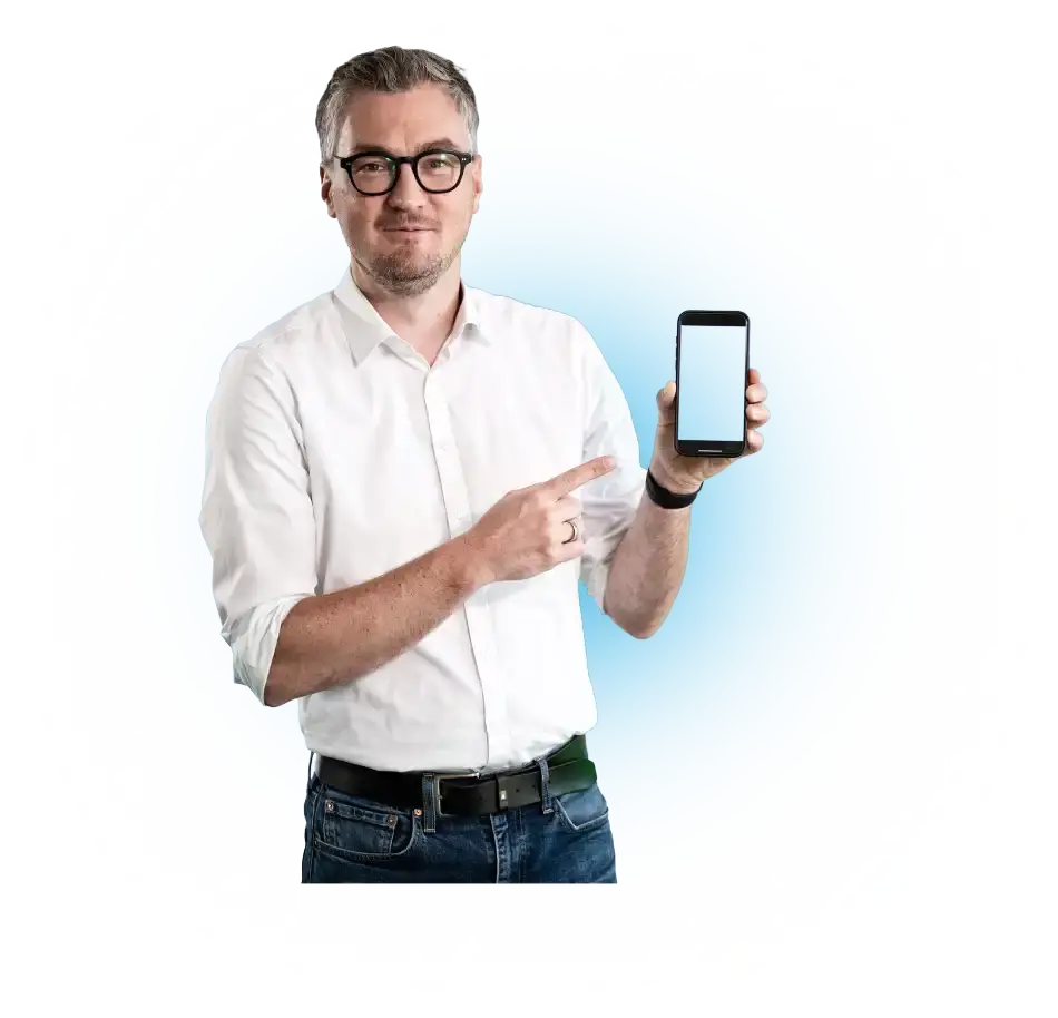 Un uomo in camicia bianca indica uno smartphone con lo schermo spento.