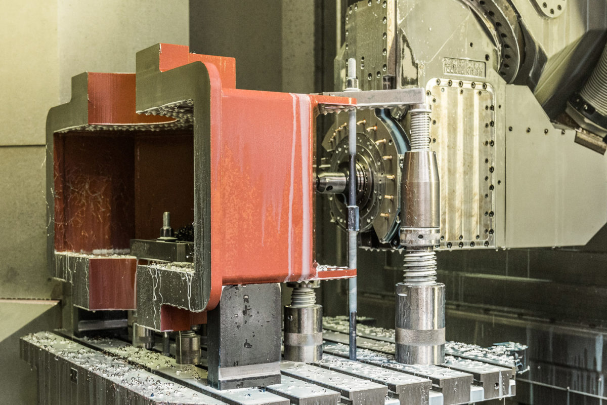 Blocco metallico in una fresatrice CNC durante la lavorazione.