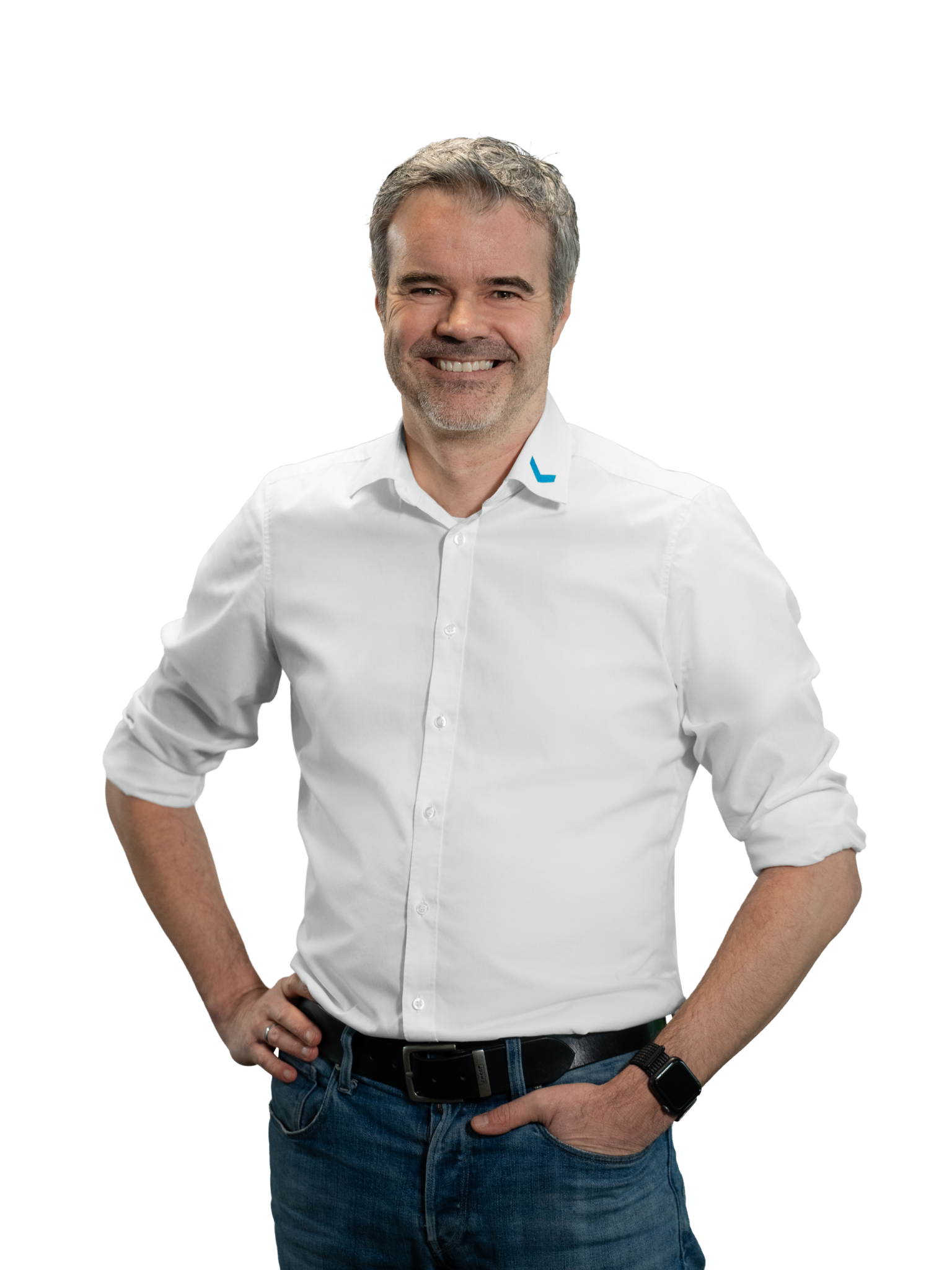 Mann in weißem Hemd und blauer Jeans lächelt in die Kamera.