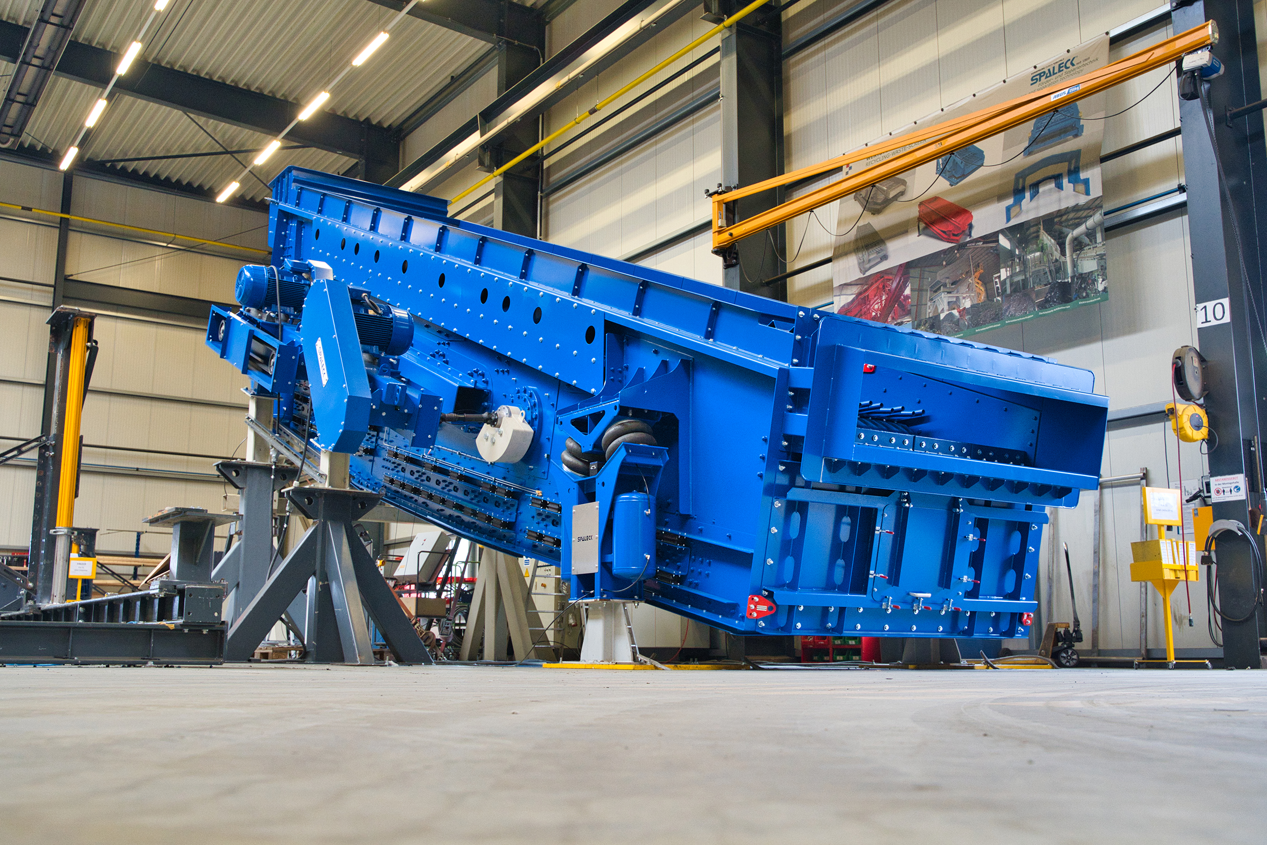 Vagliatrice blu in un capannone industriale, formazione come meccanico industriale.