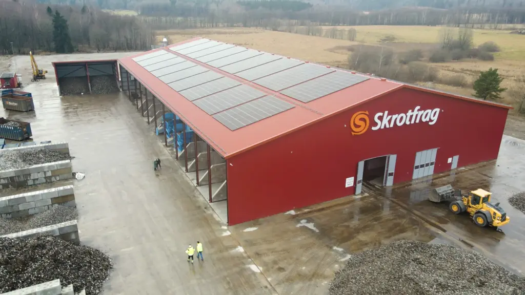 Impianto di riciclaggio Skrotfrag per metalli non ferrosi, caratterizzato da un edificio rosso e da pannelli solari.