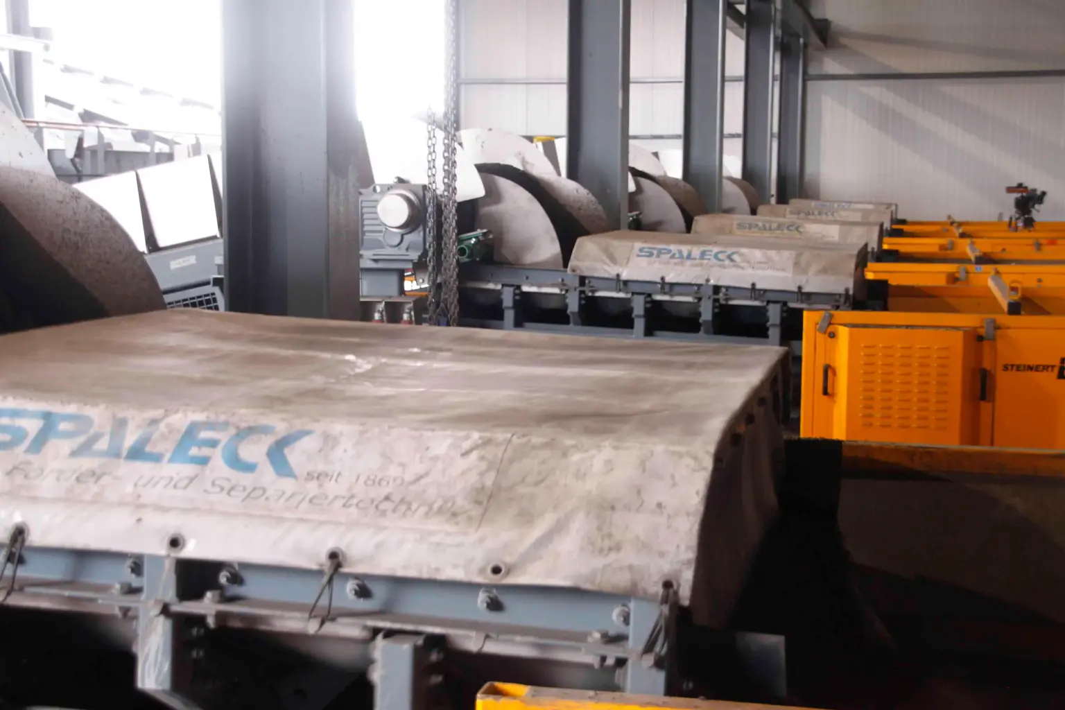 I canali di trasporto oscillanti SPALECK ActiveCLEAN in impiego nel trattamento delle scorie; in questo contesto consentono un'alimentazione senza incrostazioni verso i dispositivi di selezione