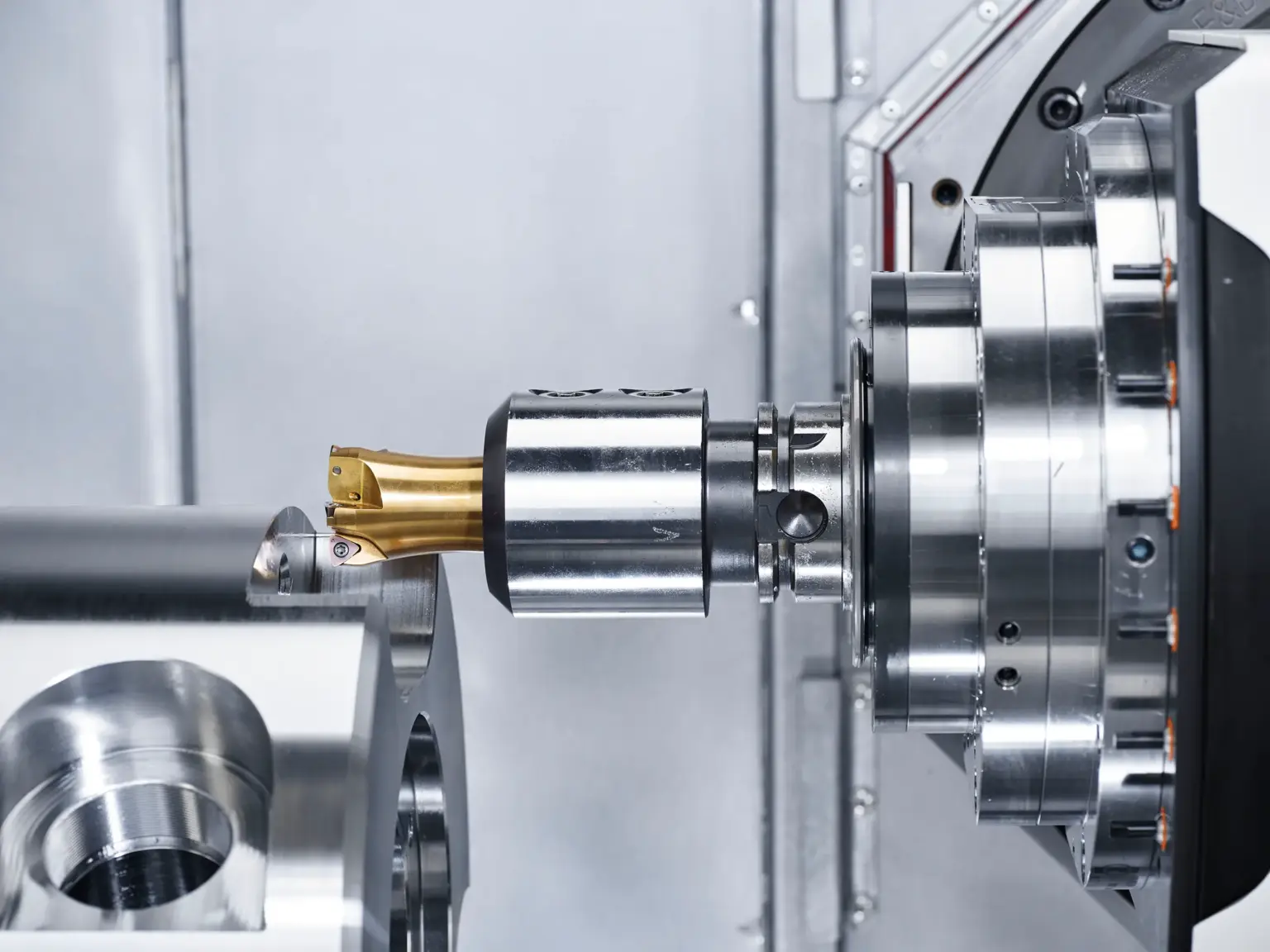 Una macchina CNC lavora un componente metallico, con particolare attenzione ai pezzi torniti di precisione.