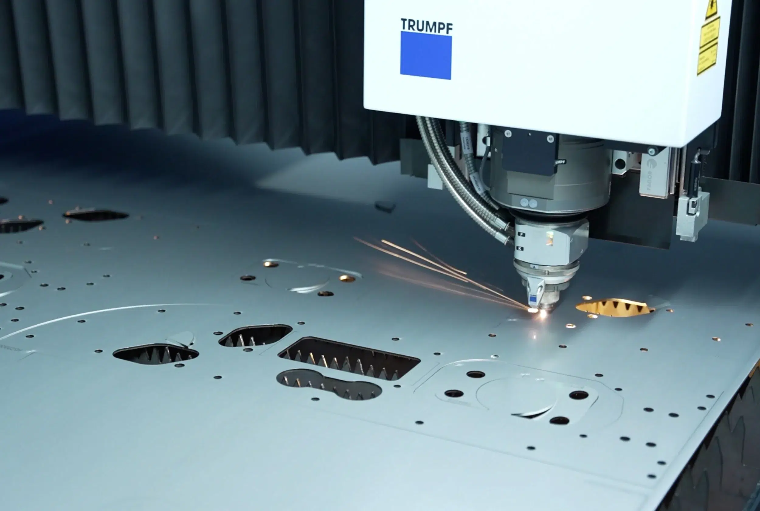 Foto dettagliata di un processo di taglio laser nella produzione di componenti lavorati al laser mediante un impianto di taglio laser