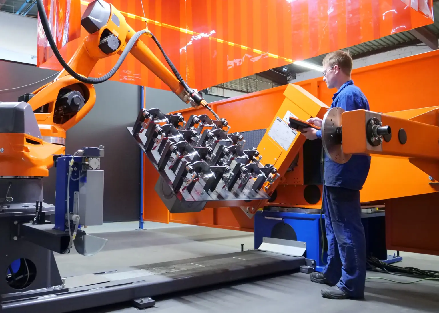 Un tecnico meccanico istruisce e addestra un robot di saldatura su come saldare un componente presso l’azienda di produzione conto terzi SPALECK