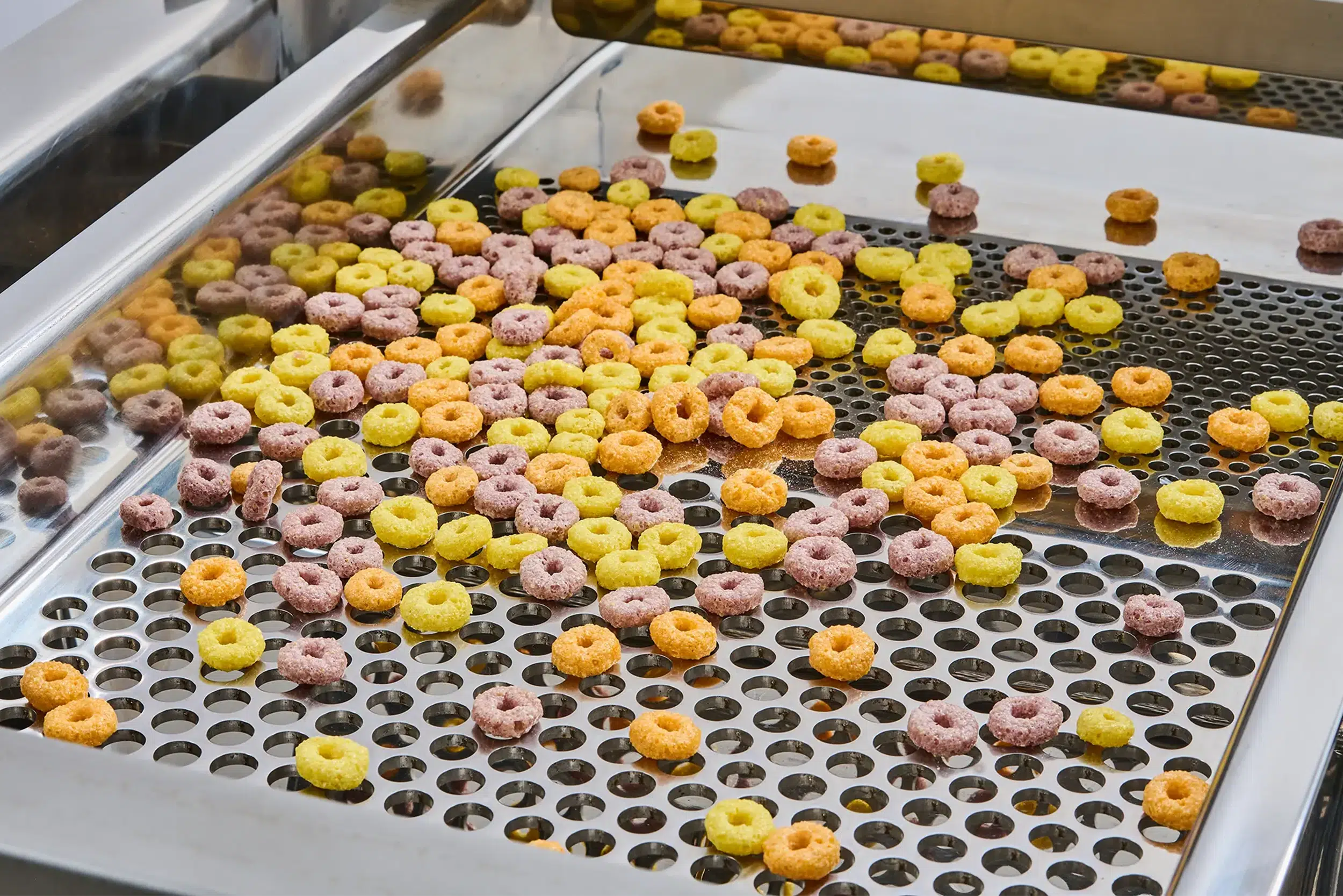 I vagli per alimenti separano gli anelli di cereali colorati su un vaglio.