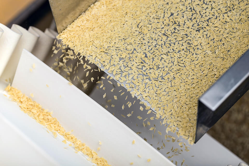 Alimentazione e dosaggio mediante un canale vibrante nella produzione alimentare