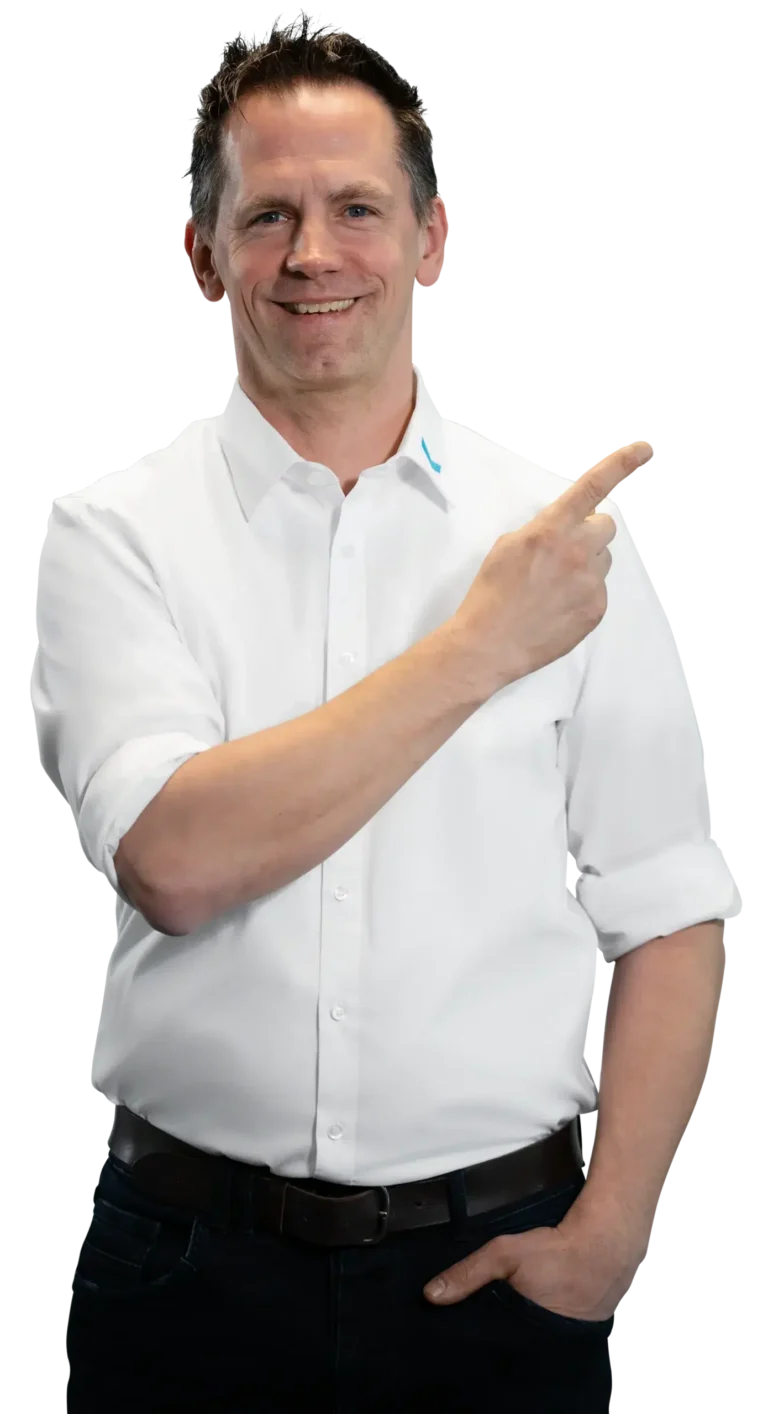 Un uomo in camicia bianca indica sorridendo di lato.