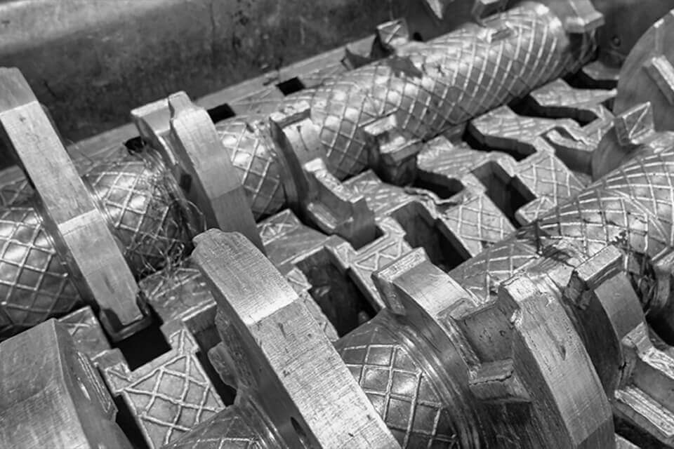 Primo piano dei rulli metallici in una vagliatrice per il riciclaggio dei metalli.