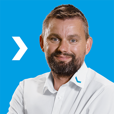 Mann in weißem Hemd vor blauem Hintergrund.