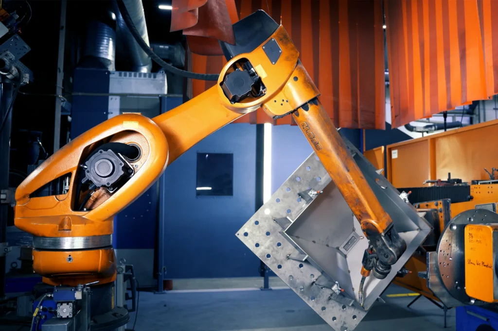 Un robot di saldatura si appresta a eseguire la saldatura automatizzata di un componente destinato all'industria ferroviaria. La foto è stata scattata presso l'azienda di produzione conto terzi e lavorazione dei metalli SPALECK.