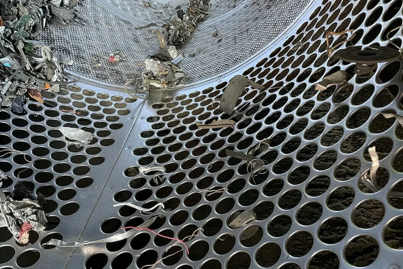 Vista interna di un vaglio a tamburo con scarti metallici.