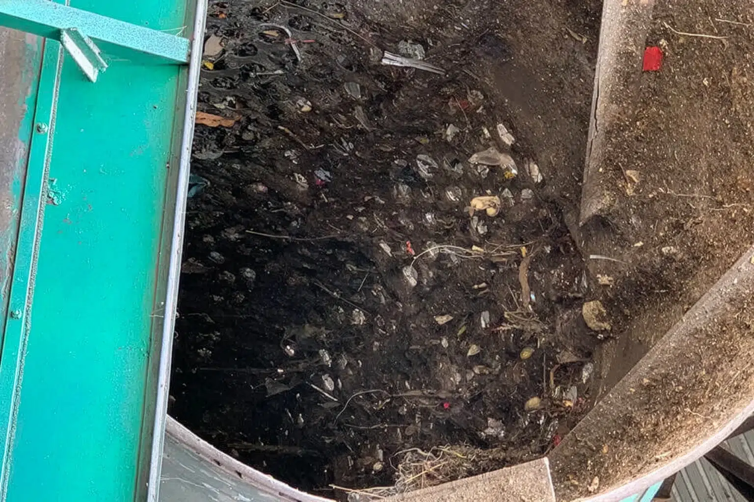 Un setaccio a tamburo con terra e materiale organico.
